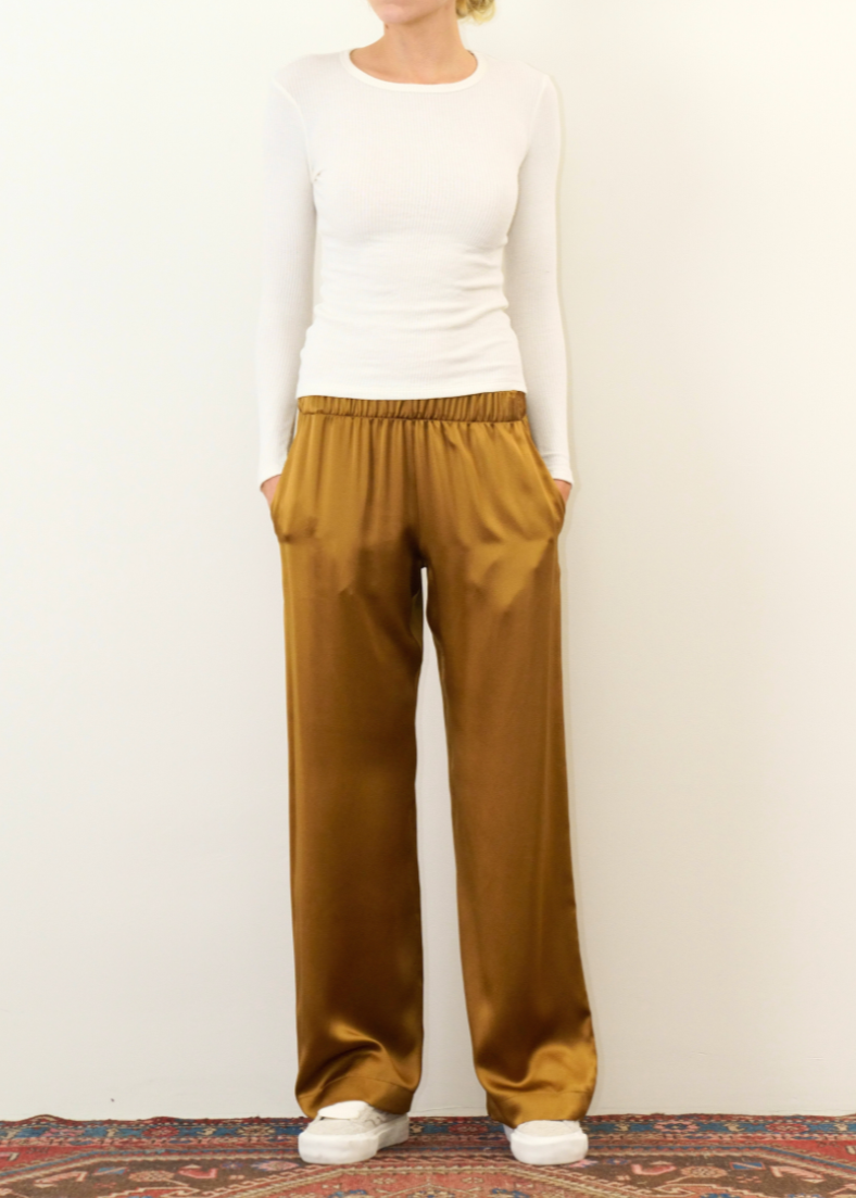 Person wearing Sabyln Brynn Wide Leg Silk Pant in Matte Gold
