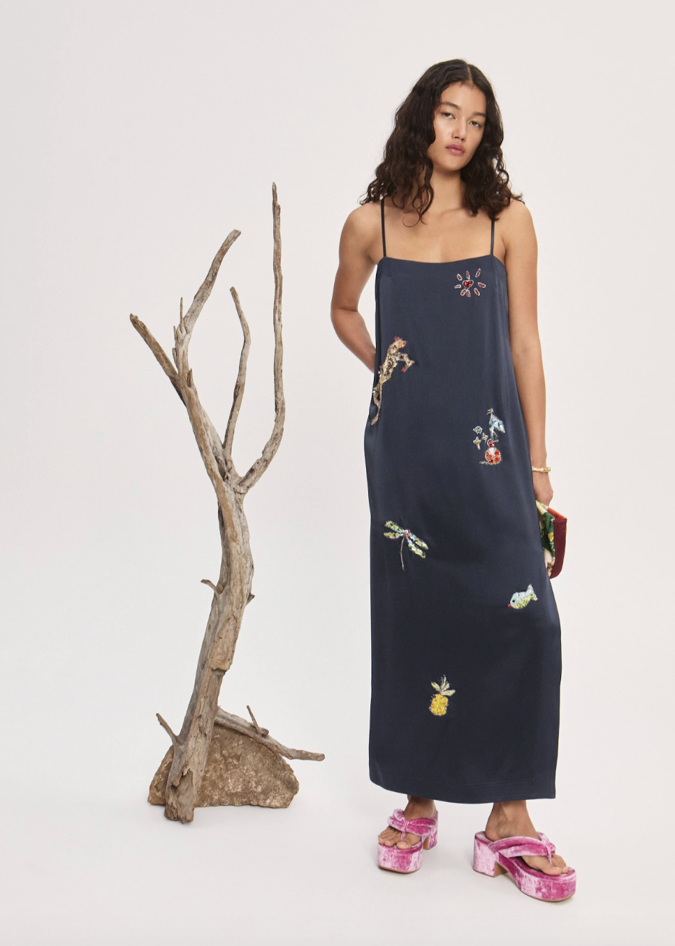 Person wearing Alemais Black slip dress with embroidered designs