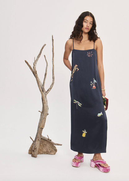 Person wearing Alemais Black slip dress with embroidered designs