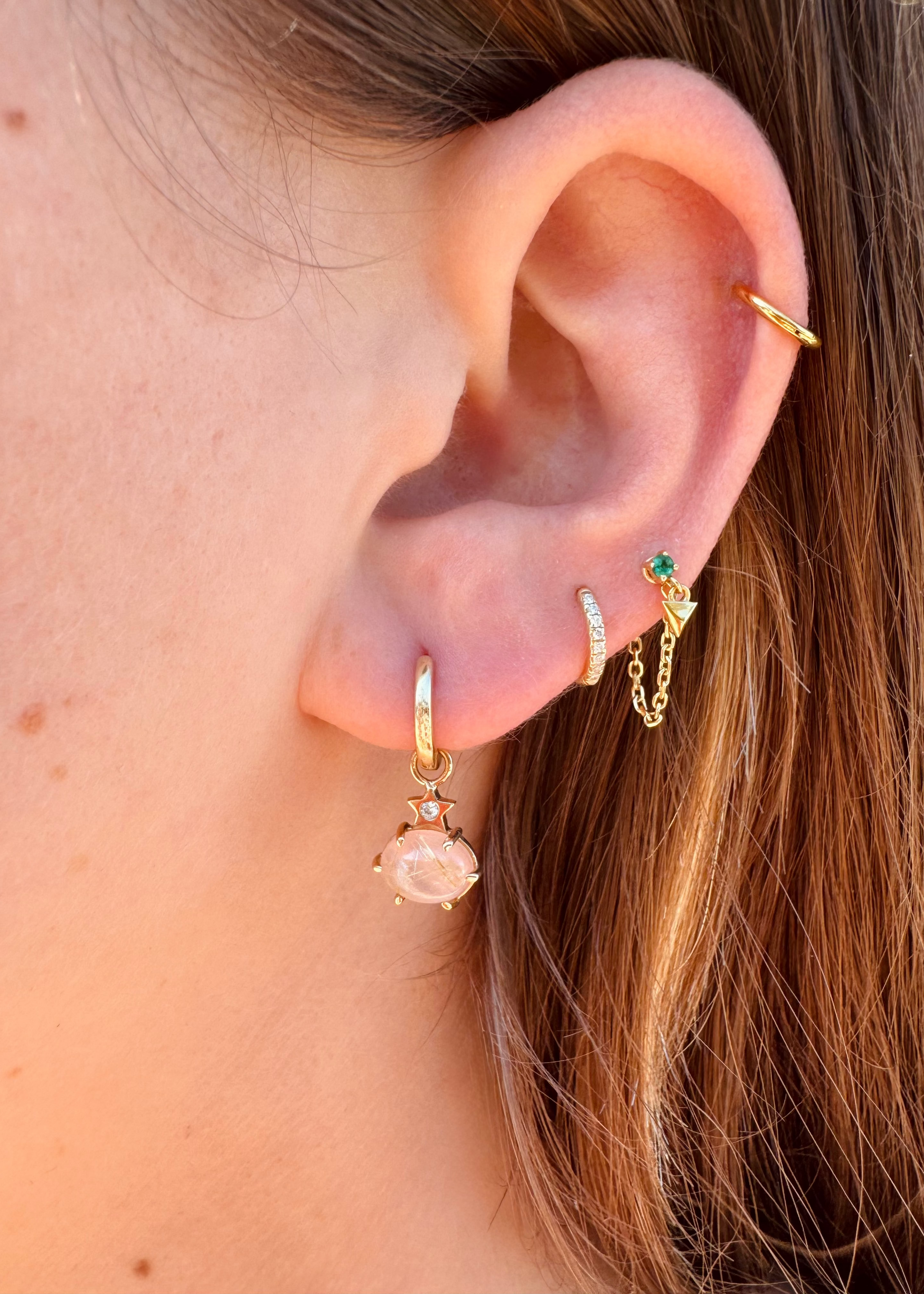 Person wearing Andrea Fohrman fine jewelry 14k yellow gold Mini Cosmo Hoop Earrings with Guava Quartz