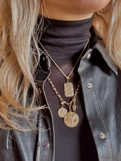 Person wearing Azlee fine jewelry 18k yellow gold New Beginnings Moon Phases Large Coin and charms