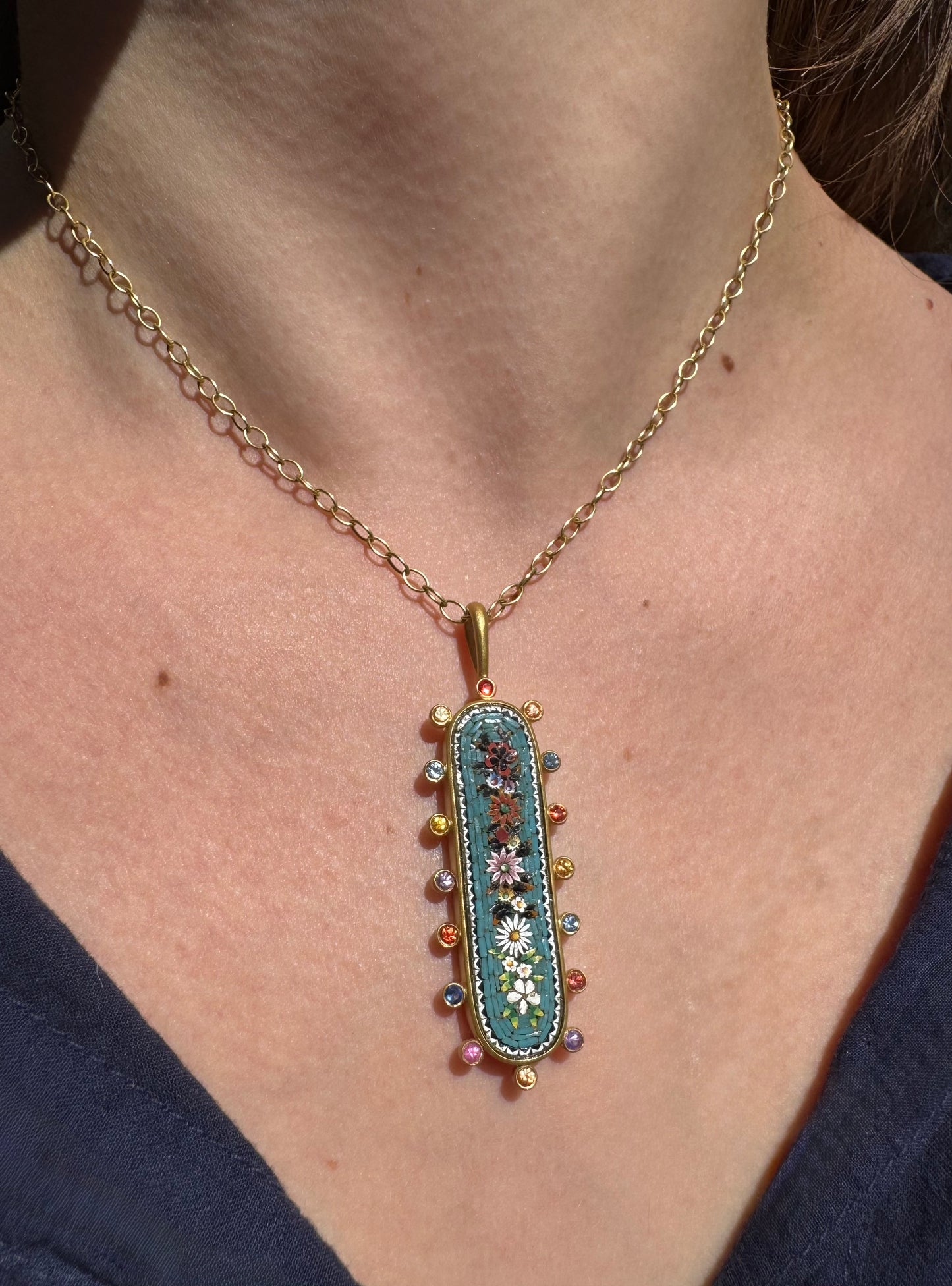 Person wearing Cathy Waterman Fine Jewelry Victorian Micro Mosaic Pendant 22k Gold with Sapphires