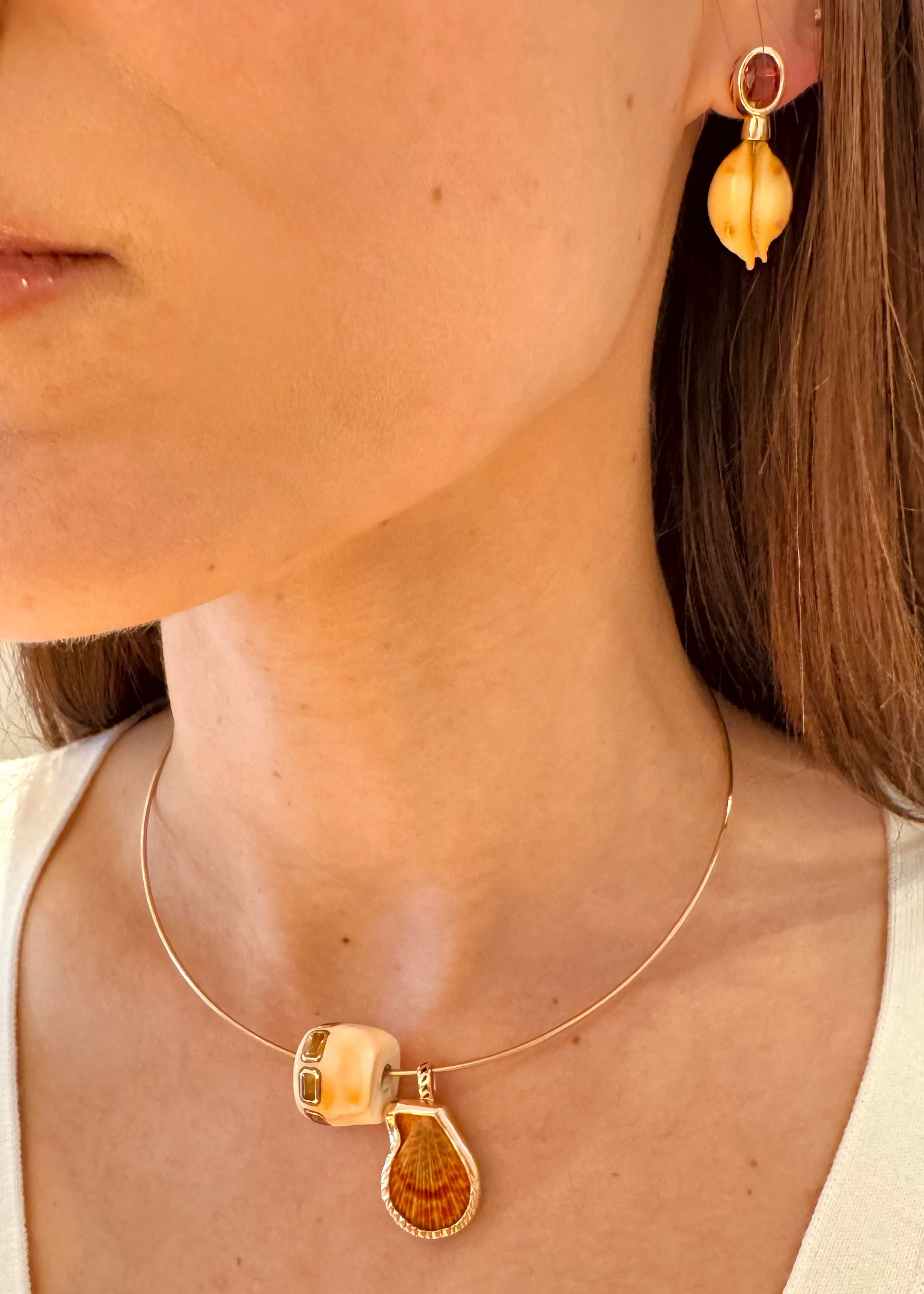 person wearing Dezso fine jewelry 18k rose gold One-of-a-Kind Natural Clam Charm Natural Champagne Shell Bead with Scapolite Natural Cowry Earrings Orange Sapphire
