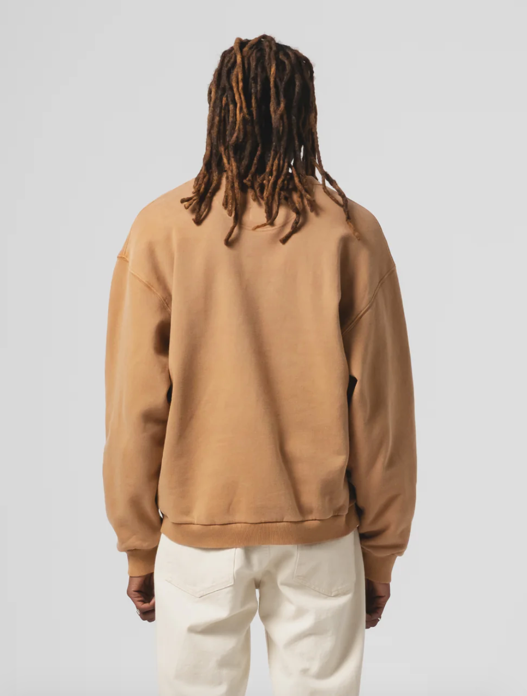 Person wearing Eat Dust Mens Unisex Detroit Sweater in Sugar