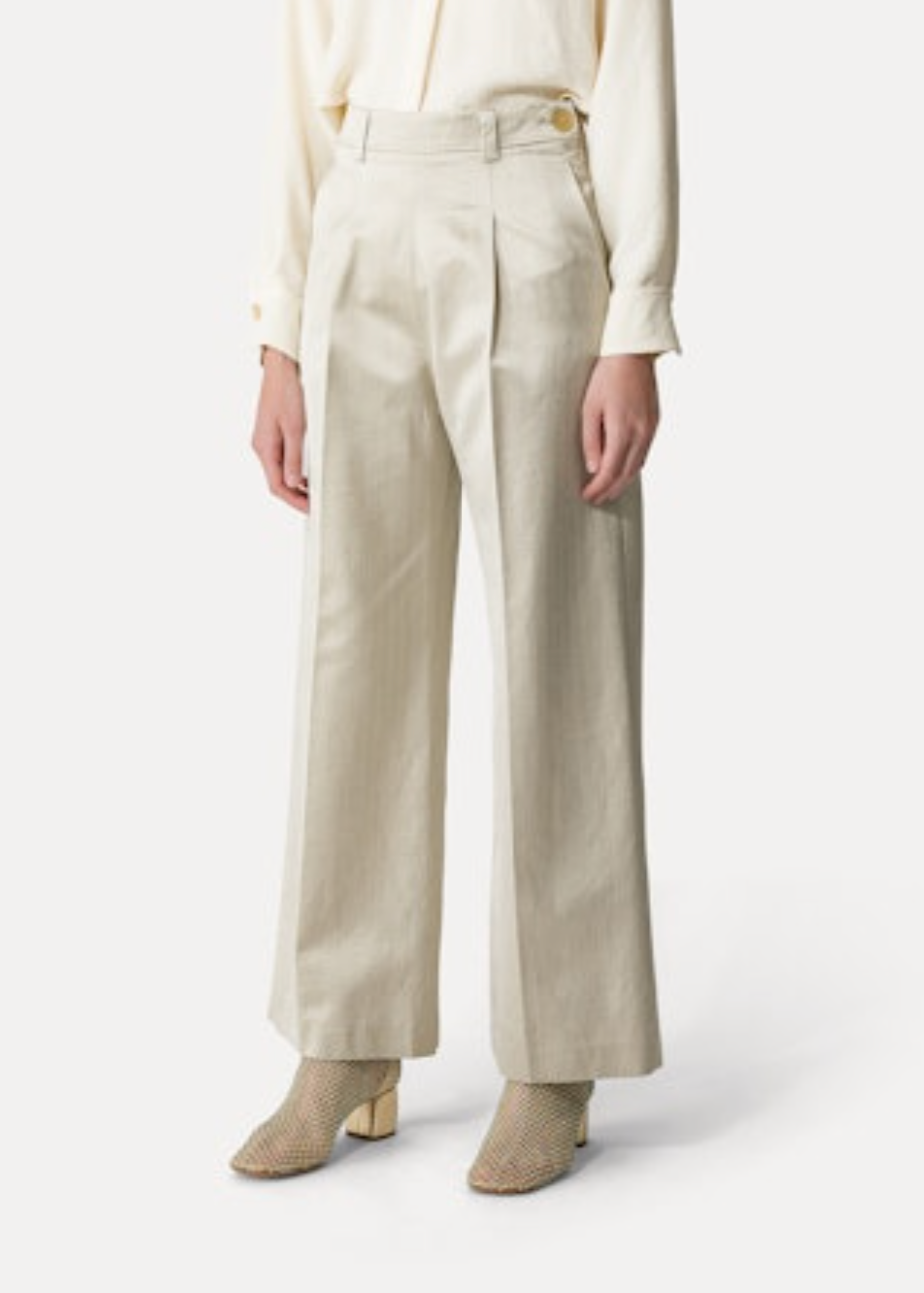 Person wearing Forte Forte High-Rise Herringbone Trousers in Sand