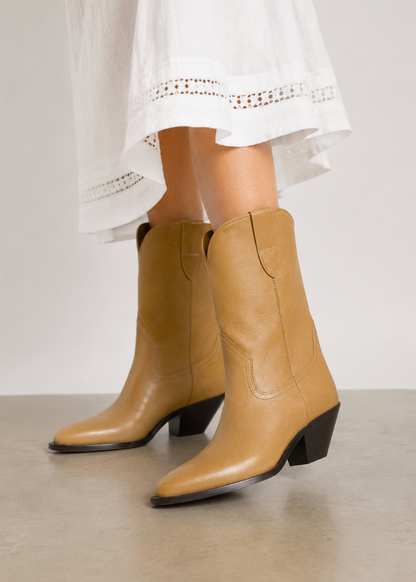 person wearing Isabel Marant womens cowboy Dahope Leather Boots in Natural tan