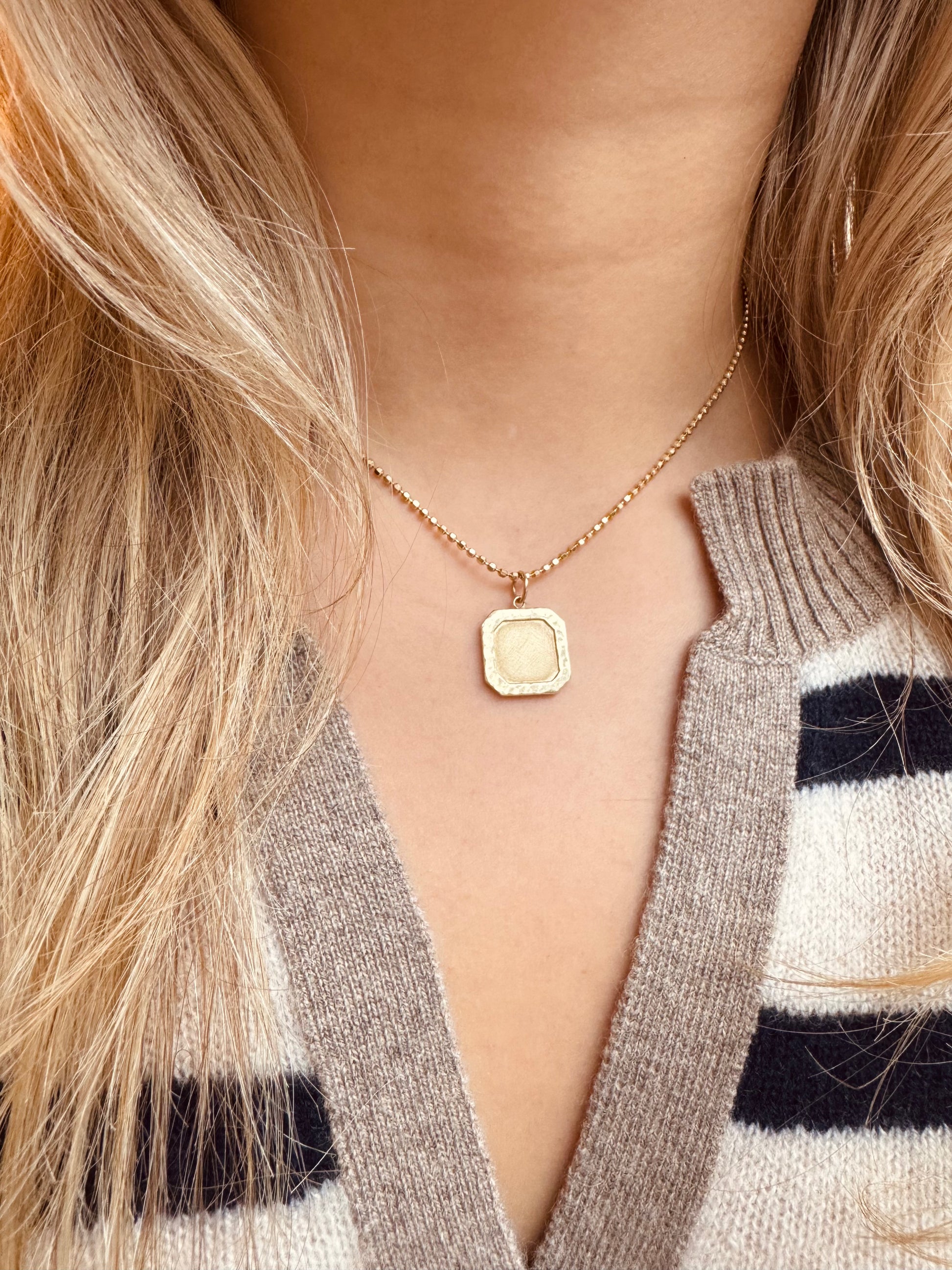 Person wearing Julez Bryant fine jewelry 14k yellow gold Daly Square Pendant