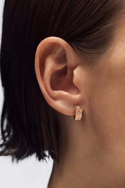 Person wearing Marie Lichtenberg fine jewelry 18k yellow gold ecrou  coco diamond hoop earring