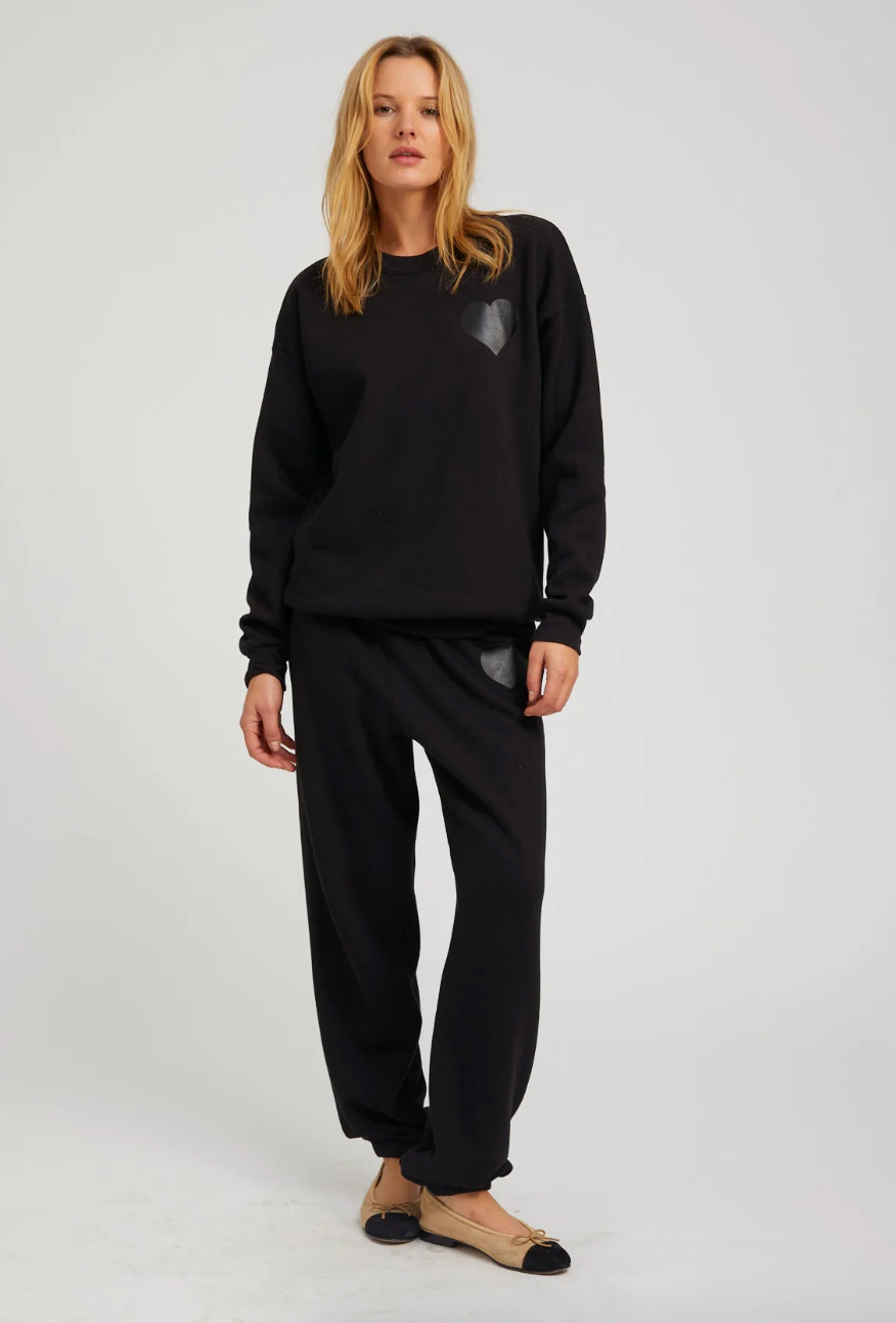 Person wearing SPRWMN womens Black & Black Glossy Heart Sweatpants