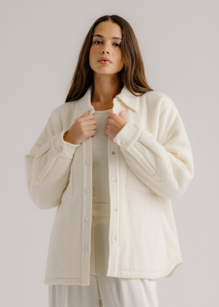 Person wearing Sablyn womens cashmere Izzy Filled Relaxed Shirt Jacket in Gardenia