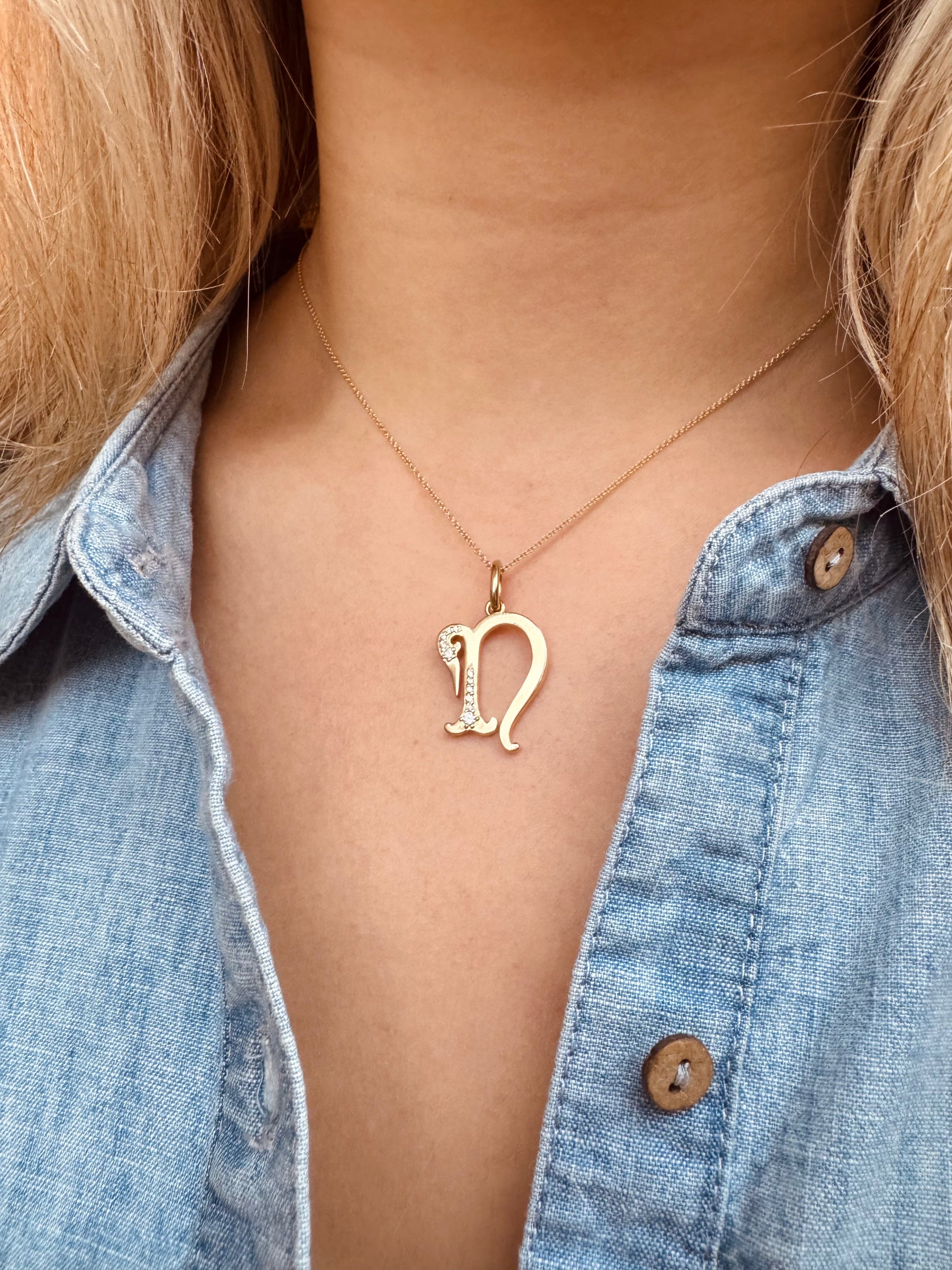 Person wearing The Moonstoned fine jewelry 14k yellow gold Diamond Initial Pendant