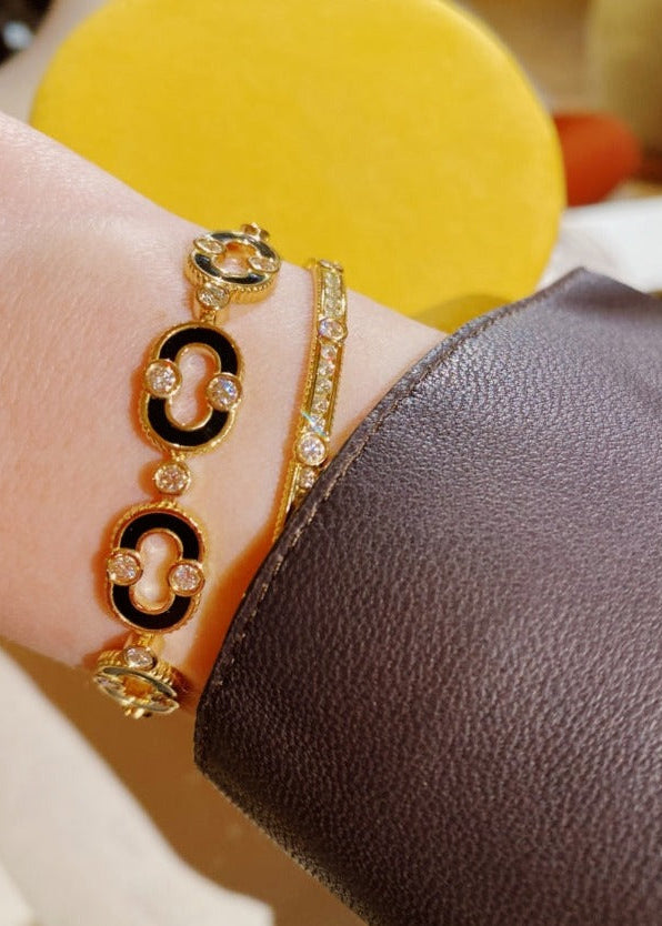 Person wearing Viltier fine jewelry 18k yellow gold Magnetic Enchainée Bracelet with Onyx and Diamonds