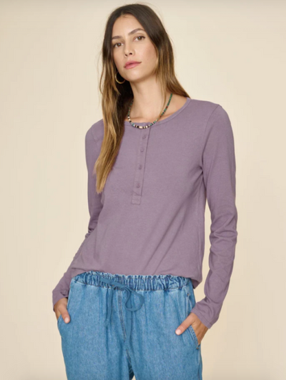 Person wearing Xirena Langley Long Sleeve Henley Tee in Purple Haze