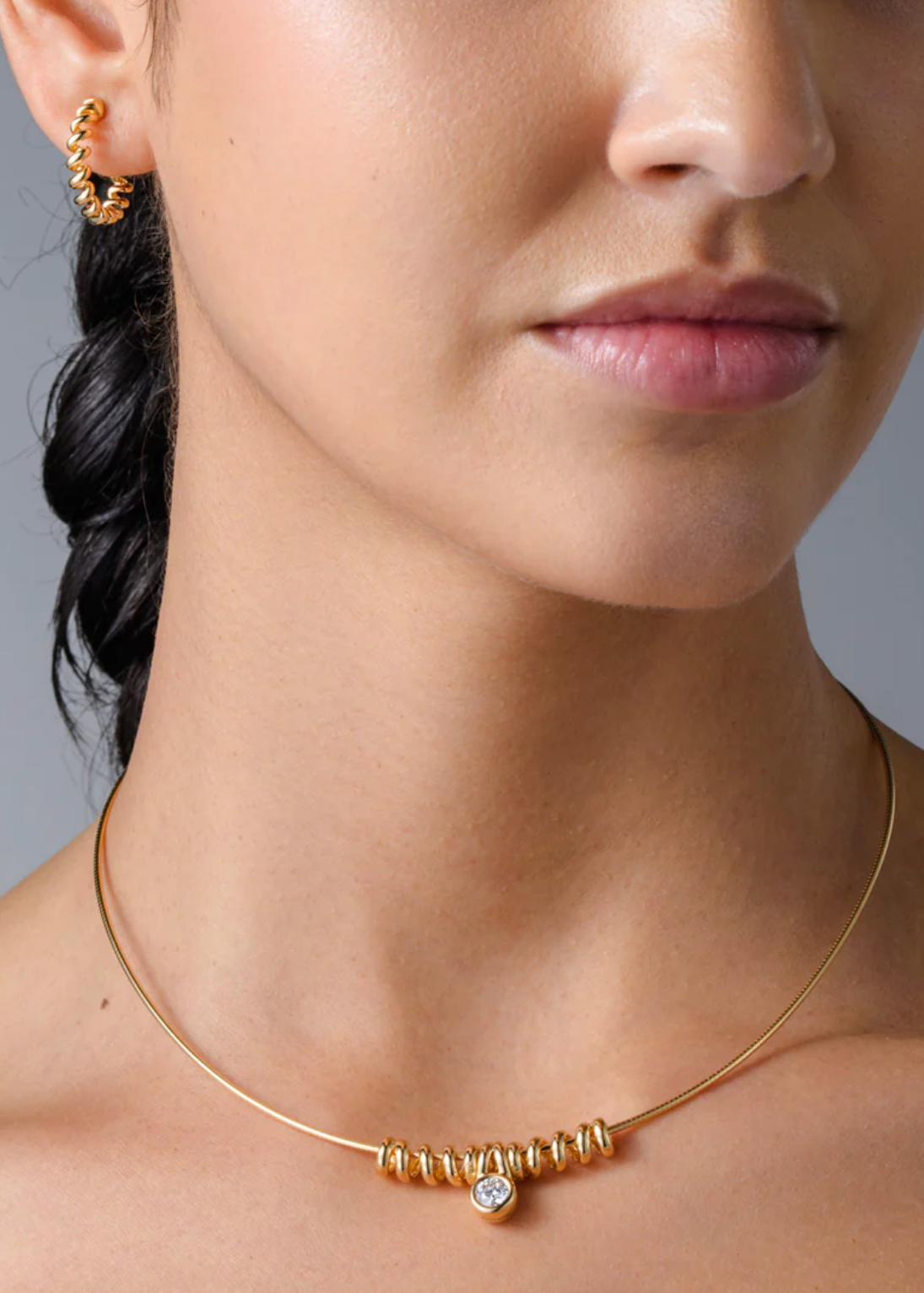 person wearing boochier fine jewelry 18k yellow gold Slinkee Bumper on nostalgia chain with diamond charm
