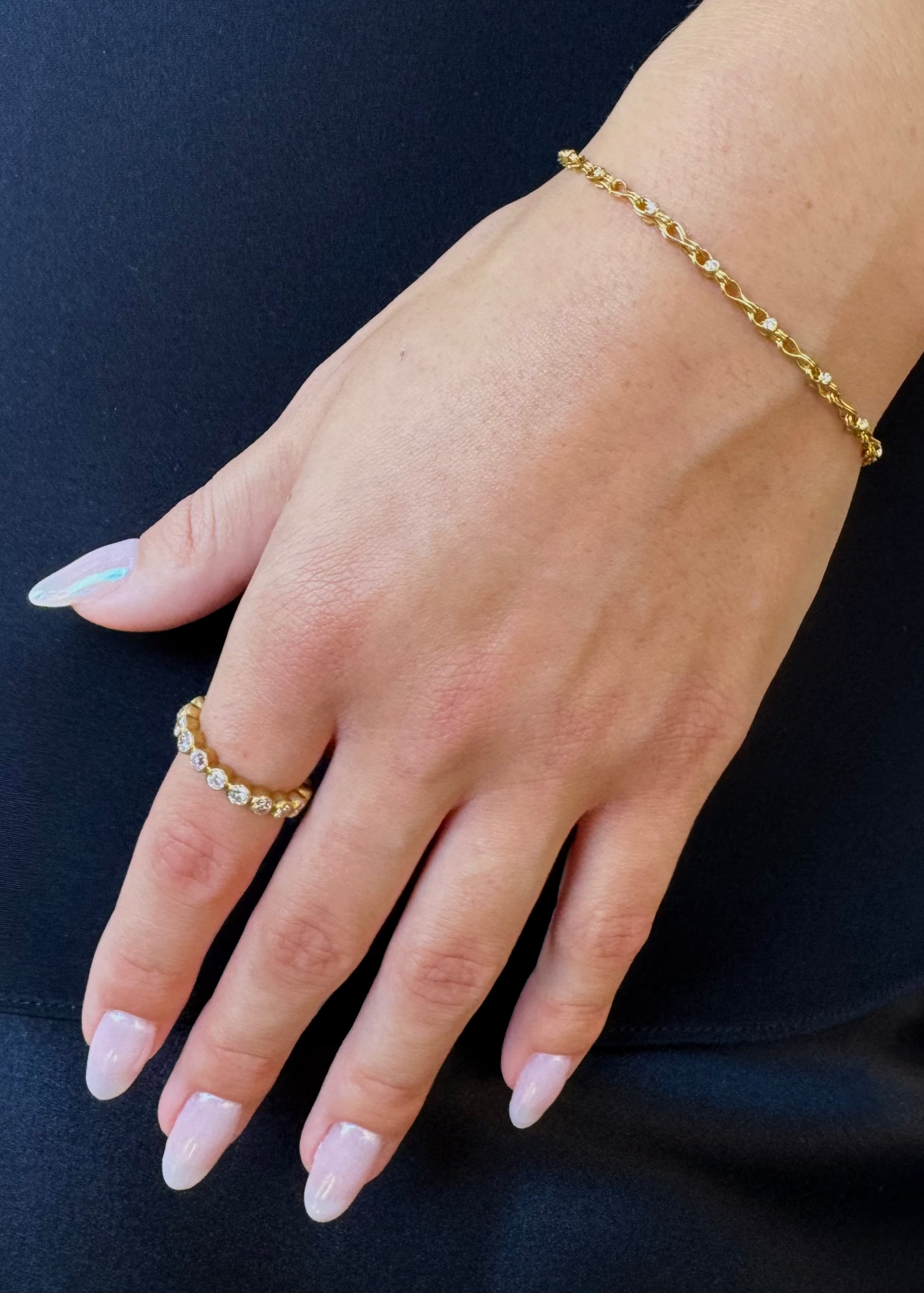 person wearing camille beinhorn fine jewelry 22k yellow gold Handwoven Diamond Chain Bracelet old mine cut diamond eternity band