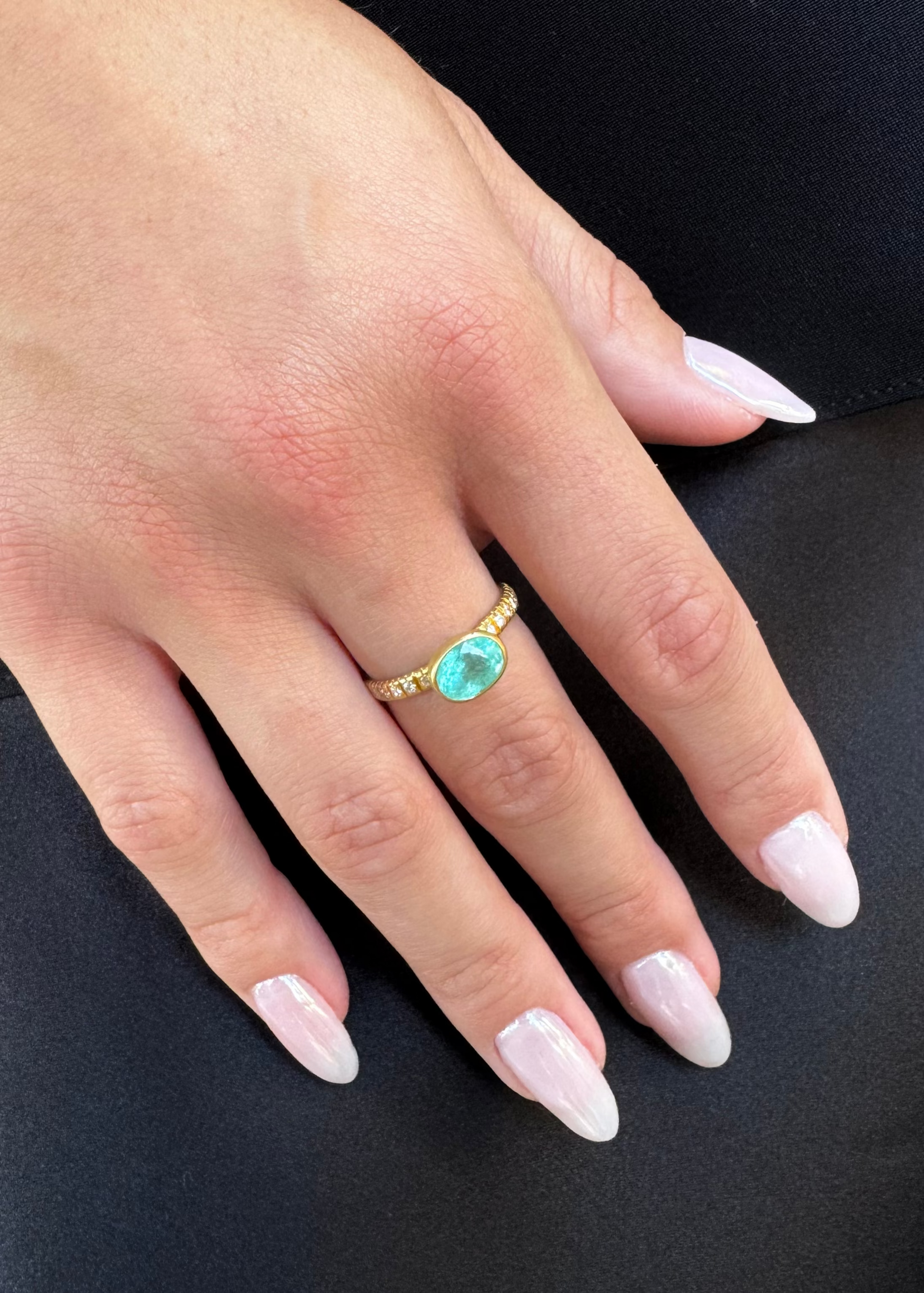 person wearing camille beinhorn fine jewelry 22k yellow gold diamond one of a kind pariaba tourmaline bezel ring