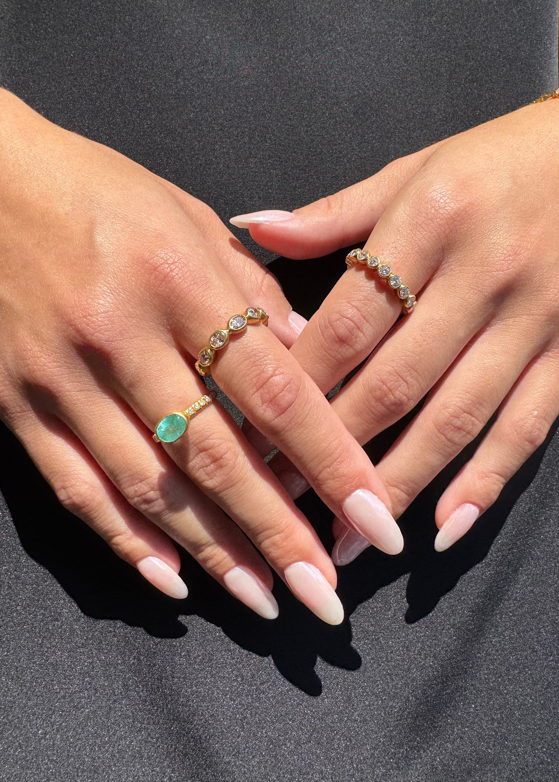 person wearing camille beinhorn fine jewelry 22k yellow gold old mine cut diamond champagne diamond Infiniti eternity Band one of a kind pariaba tourmaline bezel ring