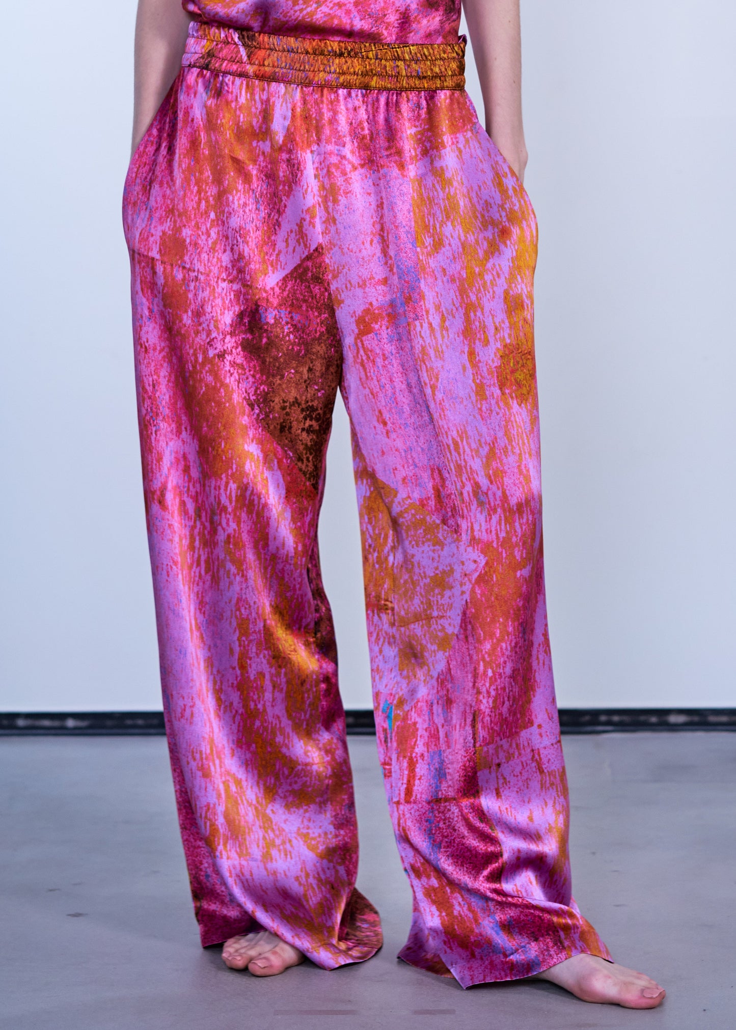 person wearing carmen molina womens silk satin printed Wide Leg Pants in Electric Lady