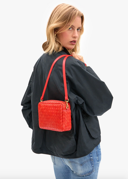 person wearing clare v womens Midi Sac in Bright Poppy Diagonal Woven crossbody bag
