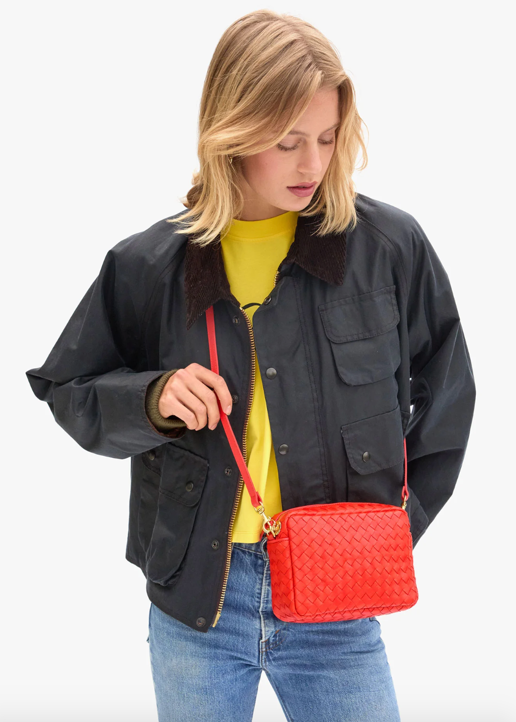 person wearing clare v womens Midi Sac in Bright Poppy Diagonal Woven crossbody bag