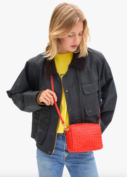 person wearing clare v womens Midi Sac in Bright Poppy Diagonal Woven crossbody bag