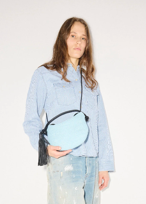 person wearing freda salvador Elis Mini Crescent Bag in Sky Blue Raffia