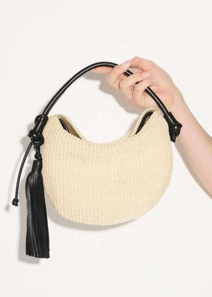 person carrying freda salvador womens Elis Mini Crescent Bag in Natural Raffia