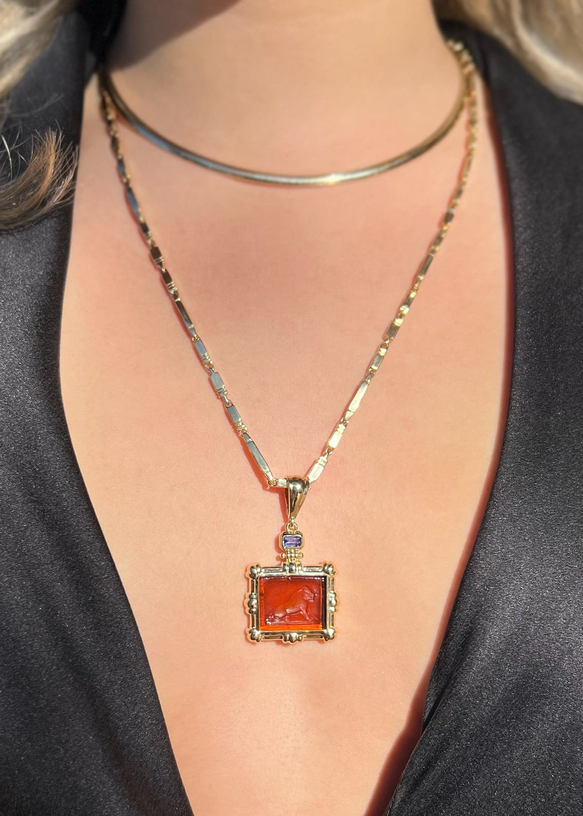 person wearing howl fine jewelry 18k yellow gold Tembo Lion Venetian Glass Pendant amber with tanzanite