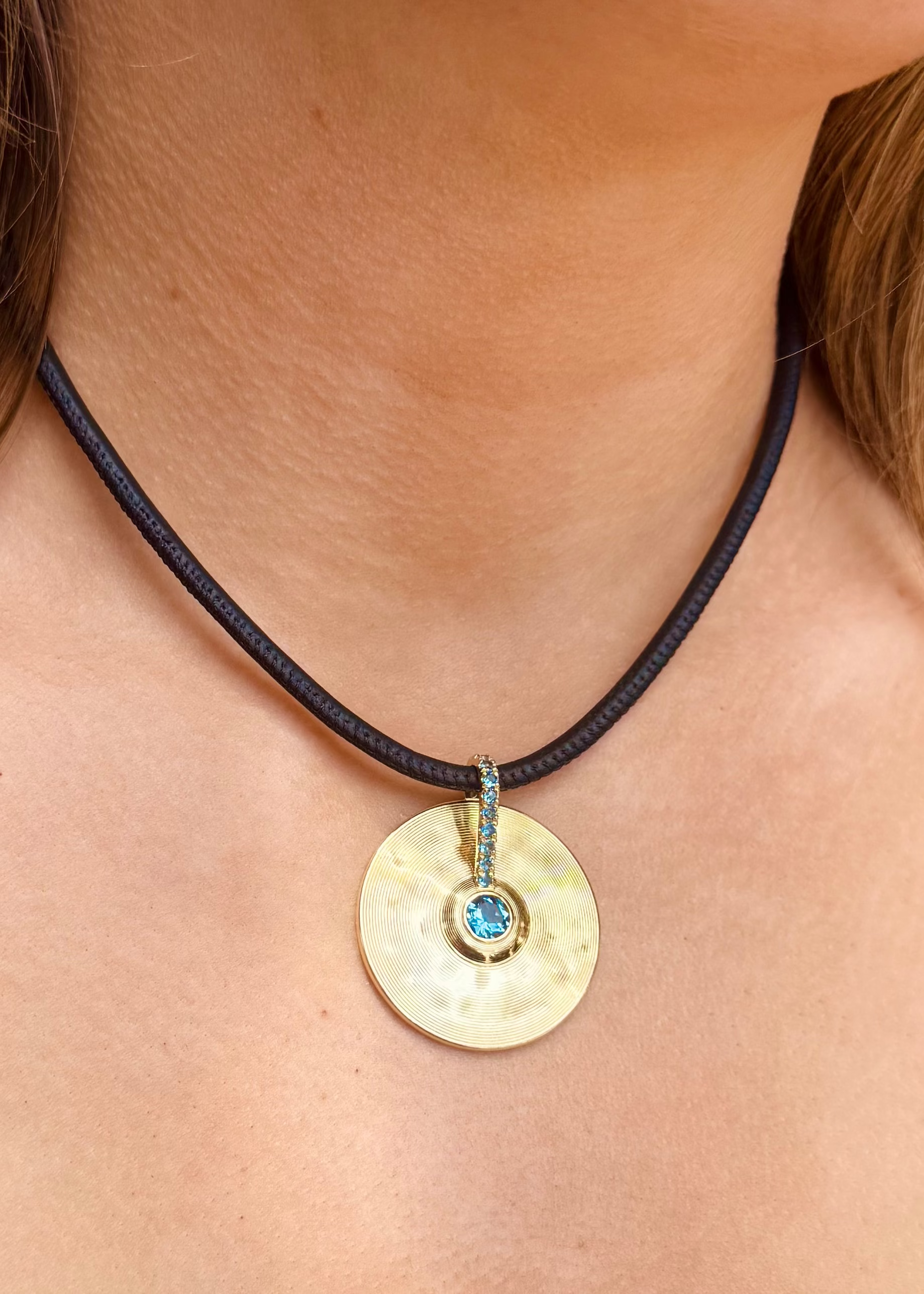 person wearing jade ruzzo fine jewelry 18k yellow gold Medium Cymbal Pendant with Aquamarine
