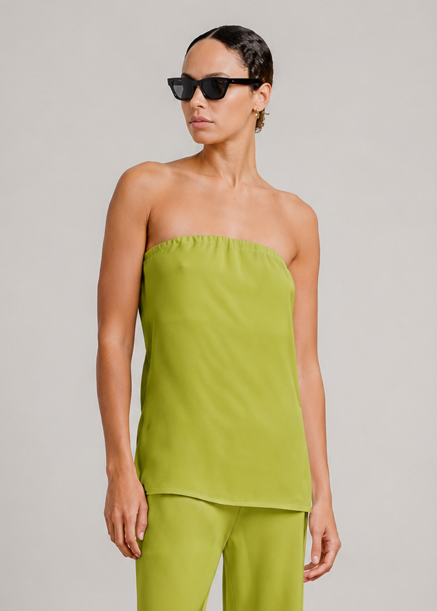 person wearing sablyn womens Camden Silk Strapless Top in Chartreuse naomi silk pants  in Chartreuse