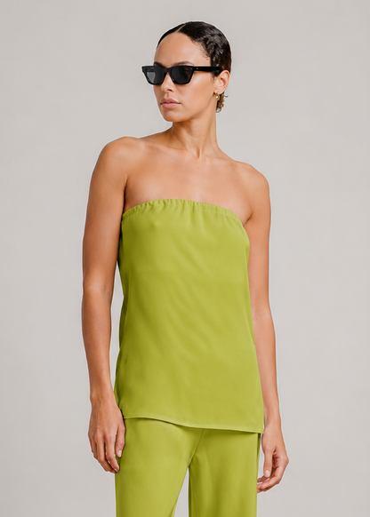 person wearing sablyn womens Camden Silk Strapless Top in Chartreuse naomi silk pants  in Chartreuse