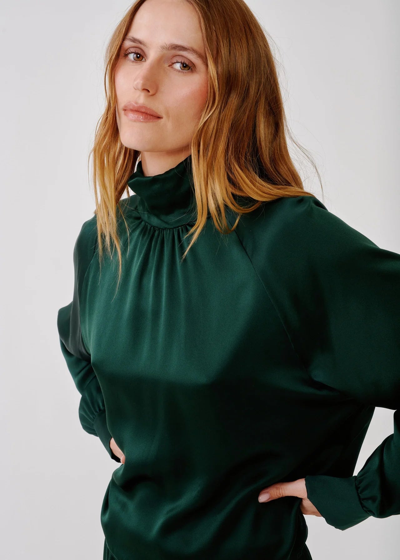 person wearing sablyn womens Nadine Slouchy Turtleneck Top in Hunter Green silk