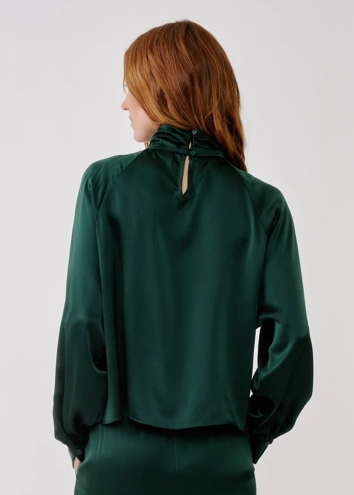 person wearing sablyn womens Nadine Slouchy Turtleneck Top in Hunter Green silk