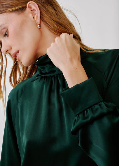 person wearing sablyn womens Nadine Slouchy Turtleneck Top in Hunter Green silk