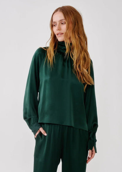 person wearing sablyn womens Nadine Slouchy Turtleneck Top in Hunter Green silk