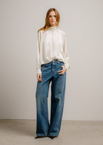 person wearing sablyn womens silk Nadine Slouchy Turtleneck Top in Gardenia