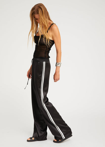 person wearing sprwmn womens Baggy Athletic Silk Pants in Black white stripe