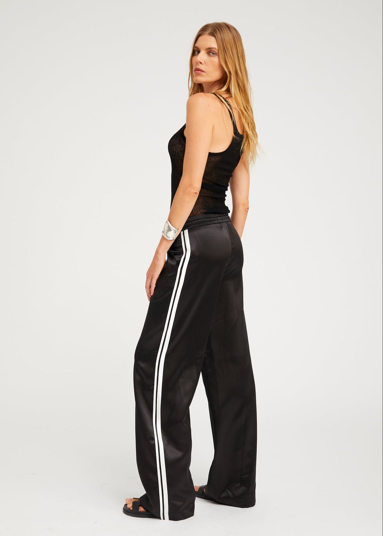 person wearing sprwmn womens Baggy Athletic Silk Pants in Black white stripe