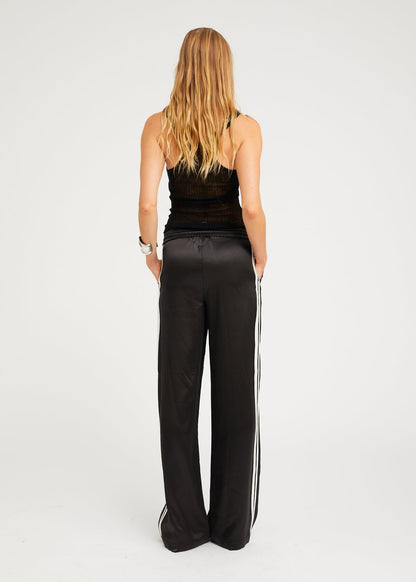 person wearing sprwmn womens Baggy Athletic Silk Pants in Black white stripe