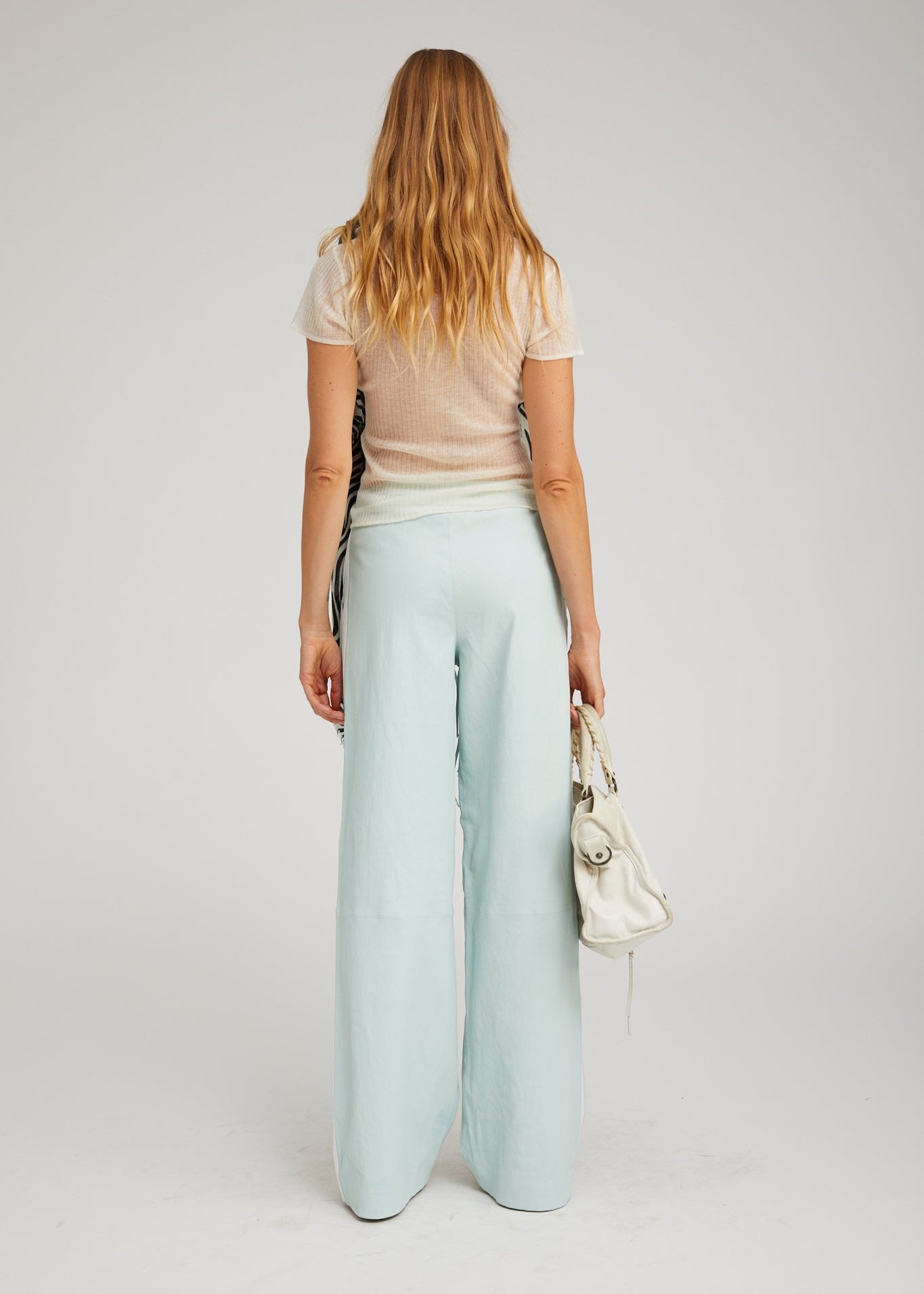 person wearing sprwmn womens Leather Baggy Athletic Pants in Mist white stripe