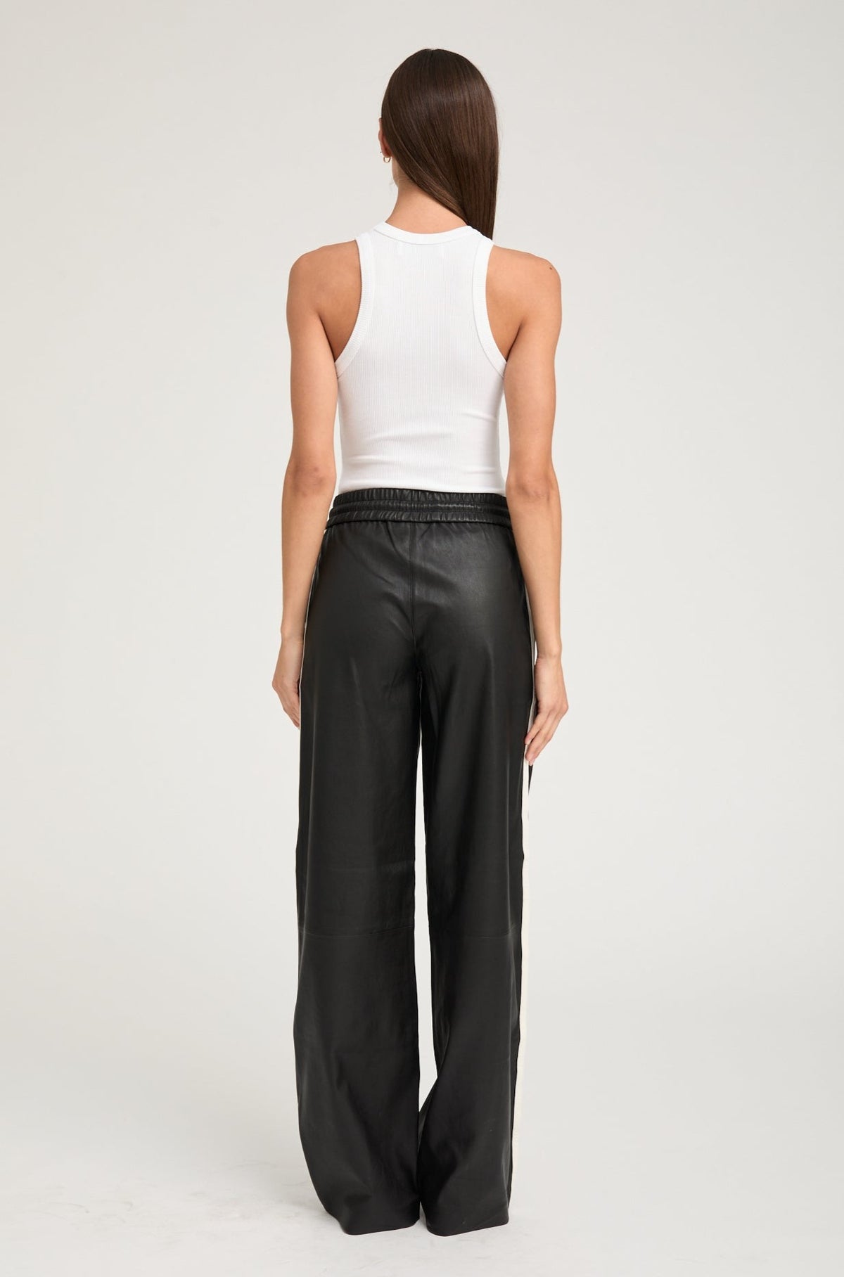 person wearing sprwmn womens Leather Baggy Athletic Stripe Sweatpants in Black